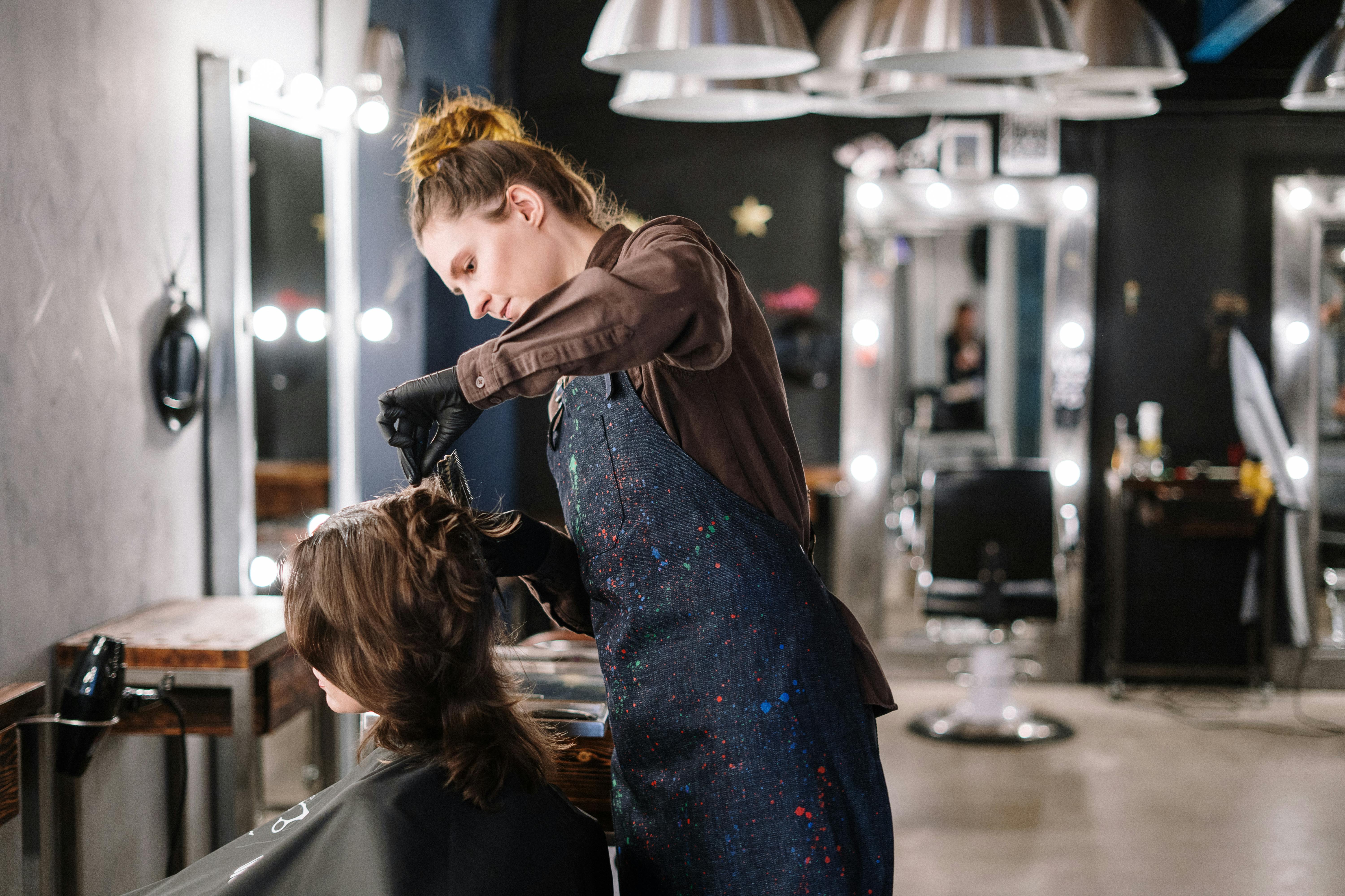 Hair stylist working on client in modern salon