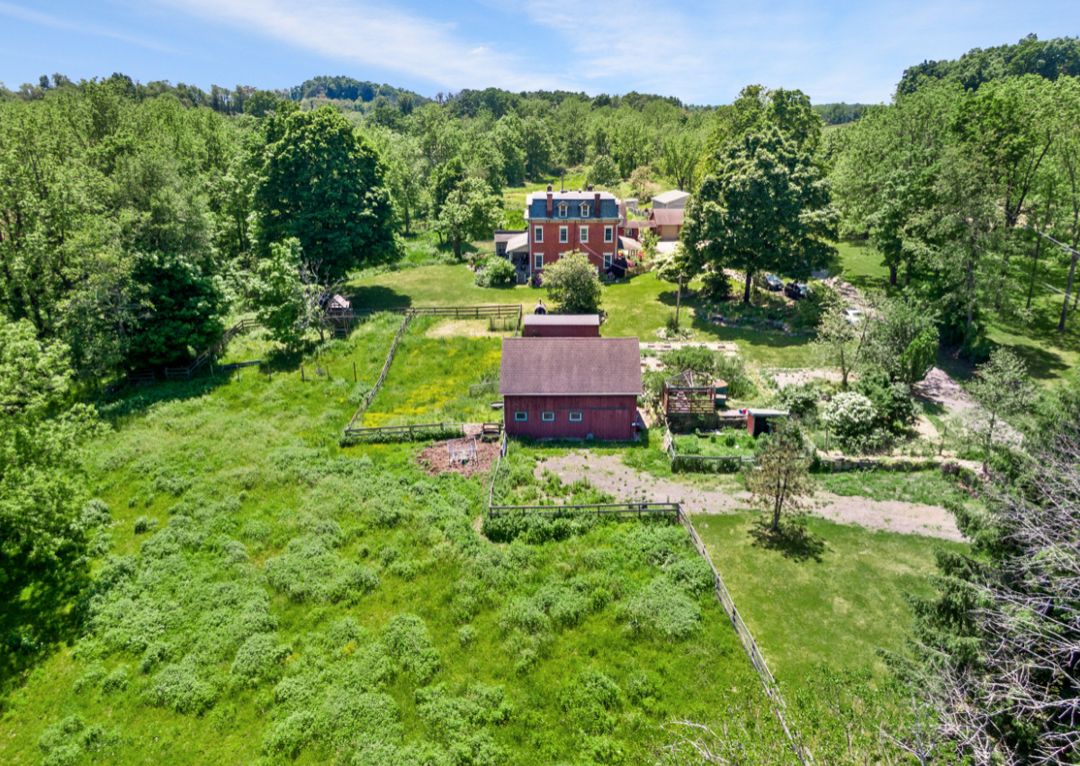 Aerial view of red farmhouse with barn