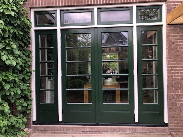 Groene houten deuren met zijpanelen